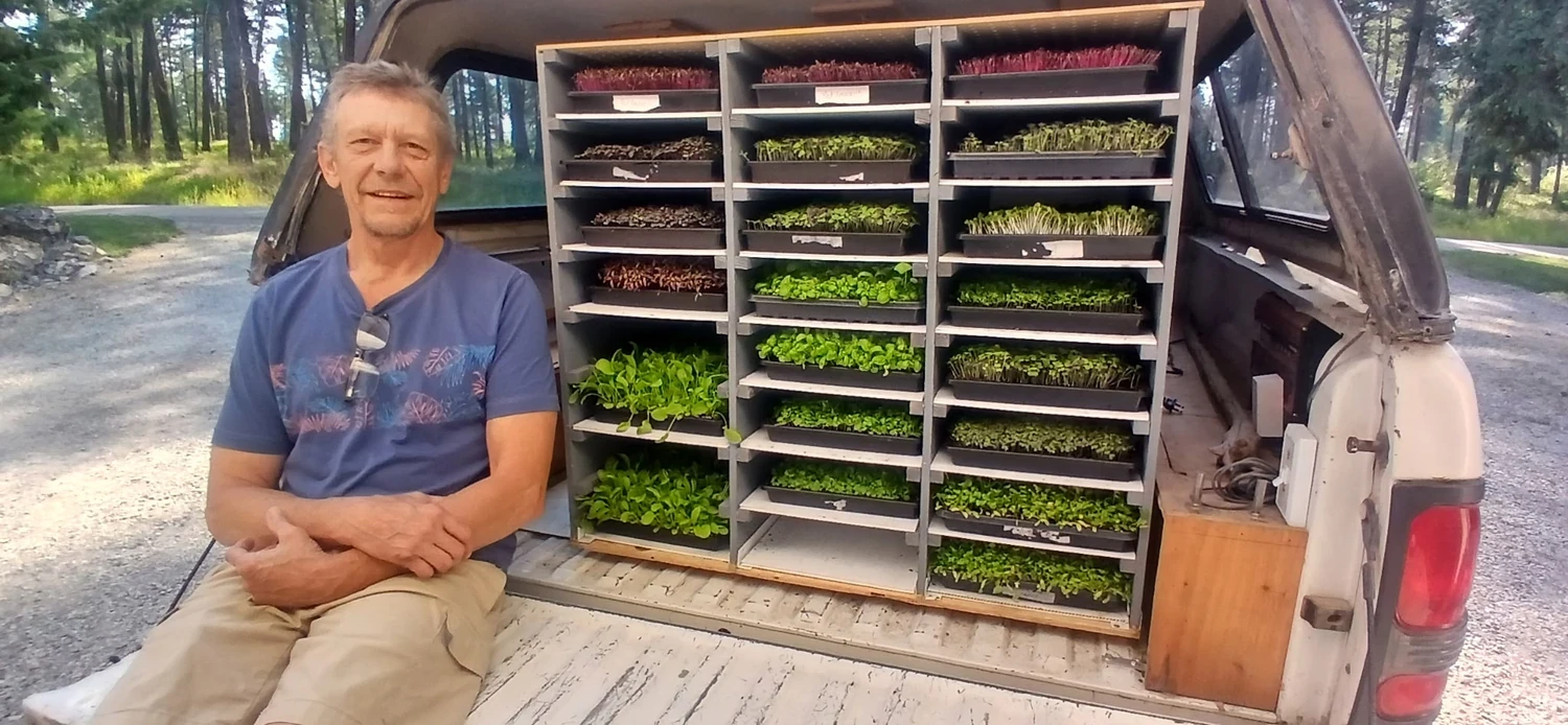 Mike with racks of living microgreens ready for delivery